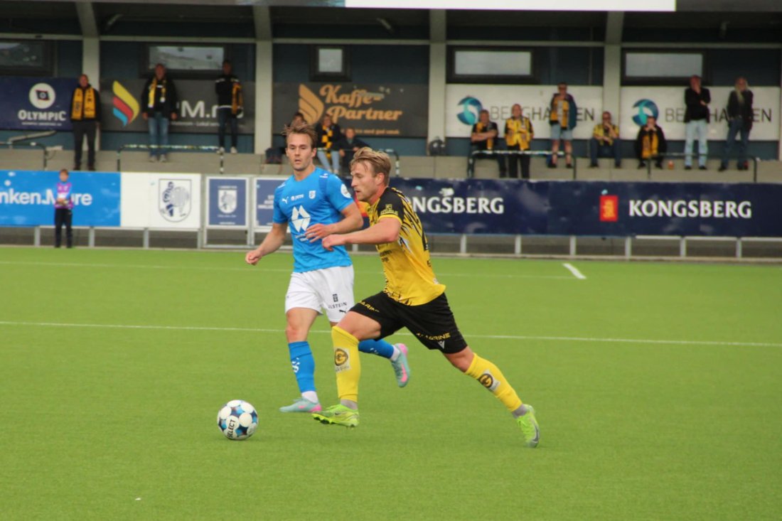 Kristian Kjeverud Eggen i fint driv mot Hødd. I bakgrunnen ser vi noen av EIK-supporterne på bortefeltet.